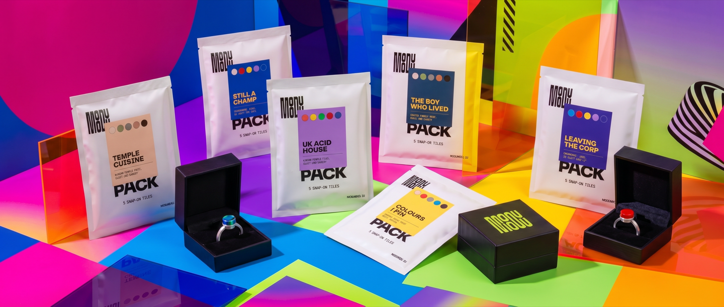 MODU MODU tile packs and two boxed rings against a colourful Memphis-inspired set — Temple Cuisine, Still a Champ, UK Acid House, The Boy Who Lived, Colours I Pin, Leaving the Corp.
